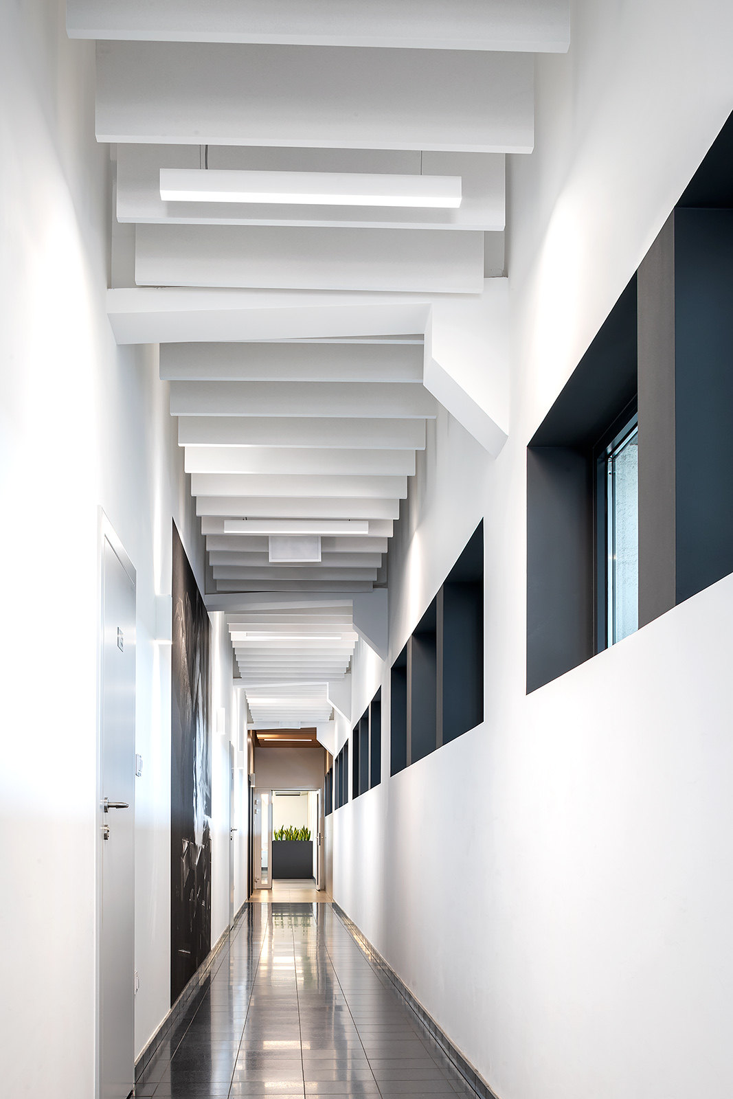 Długi korytarz, podzielony strefami kolorystycznymi.