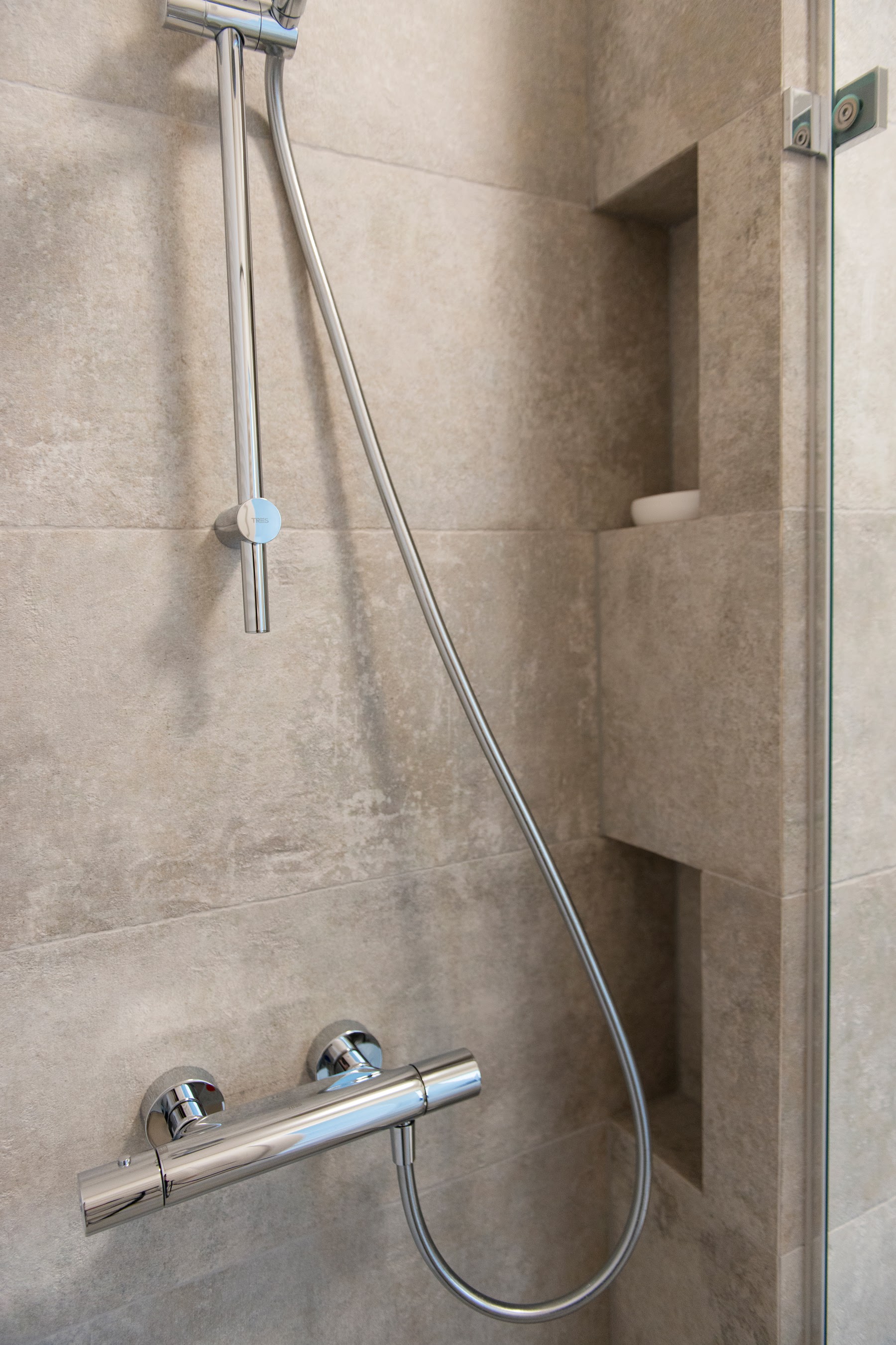 Prysznic walk in z ukrytymi wnękami na kosmetyki.