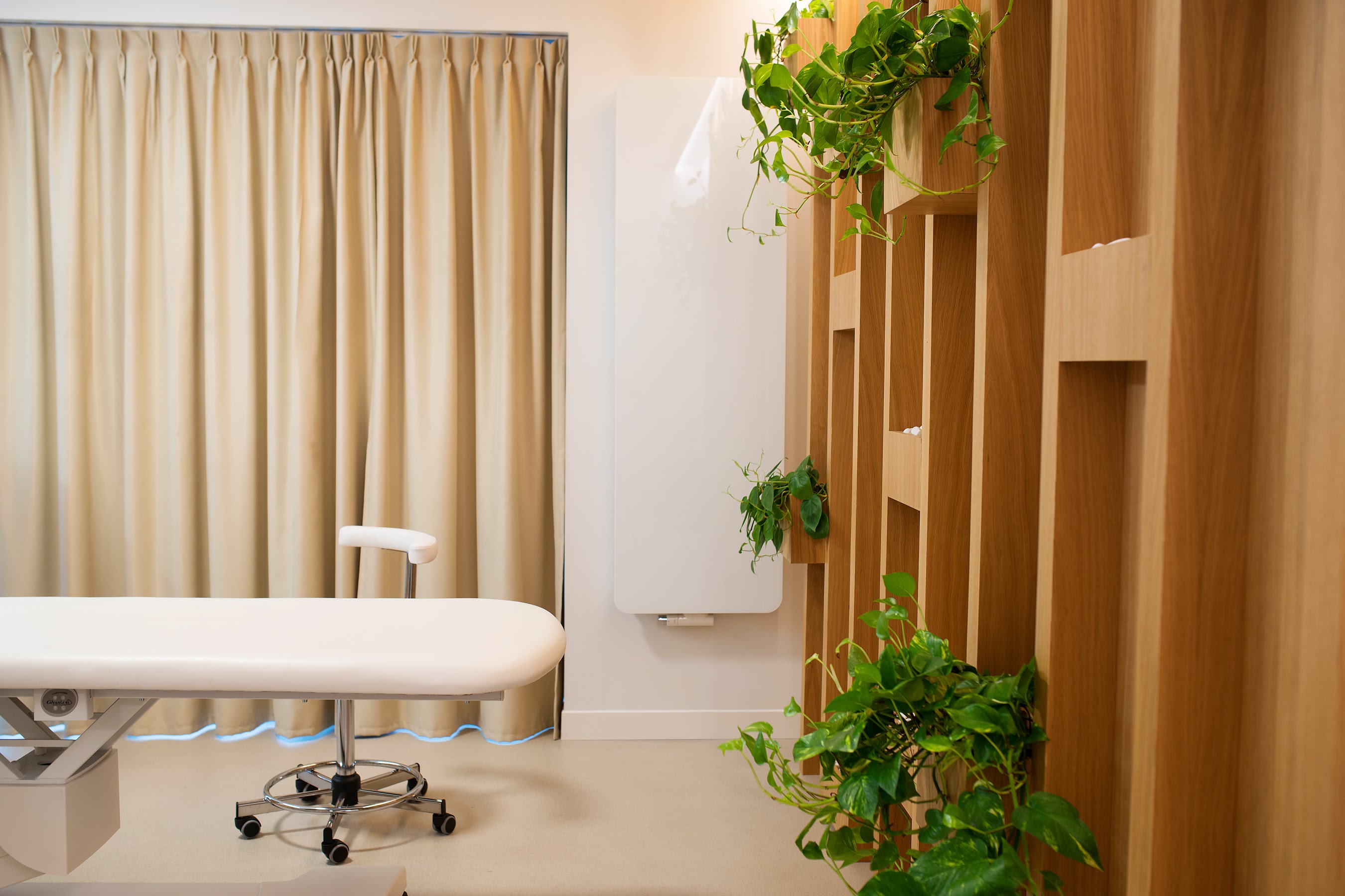 Drewniana zabudowa z roślinami, sprzyja relaksowi podczas masażu w gabinecie.