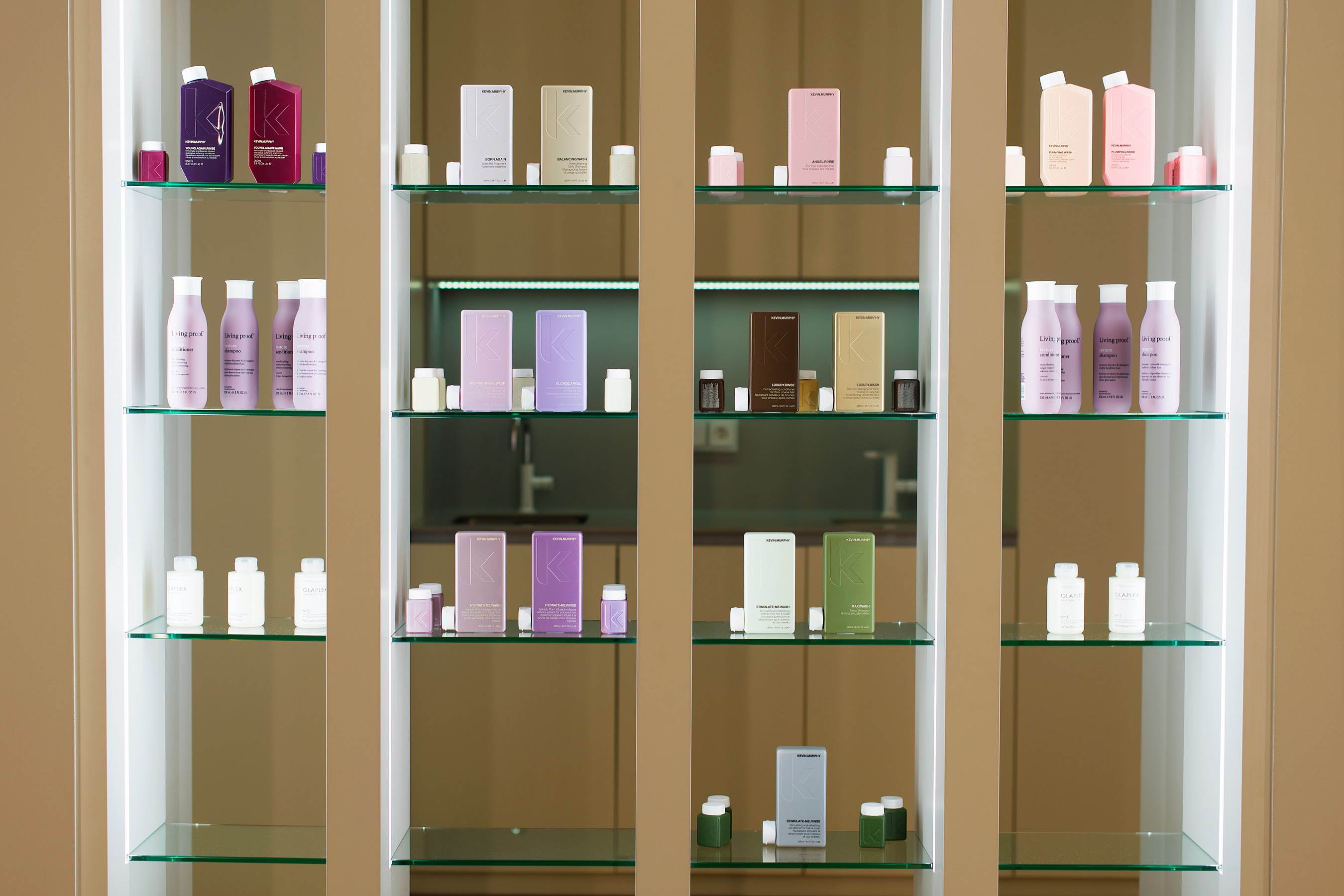 Szklane półki eksponują kosmetyki i oddzielają aneks kuchenny.